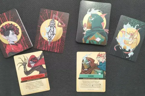 Kilka kart do gry z ilustracjami postaci fantasy i tekstem w języku polskim.