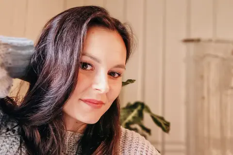 Portret Katarzyny Ciepelewskiej w swetrze, z włosami opadającymi na twarz.