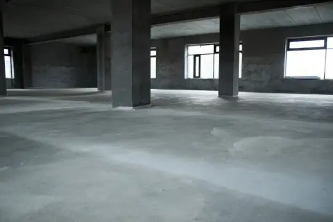 Surowa posadzka betonowa w pustym domu, idealna baza pod wykończenie. Jaki beton na posadzkę w domu wybrać?