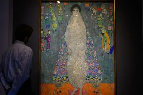 Mężczyzna podziwia portret Adele Bloch-Bauer, najdroższy obraz świata. Dzieło Gustava Klimta zachwyca bogactwem wzorów i kolorów.