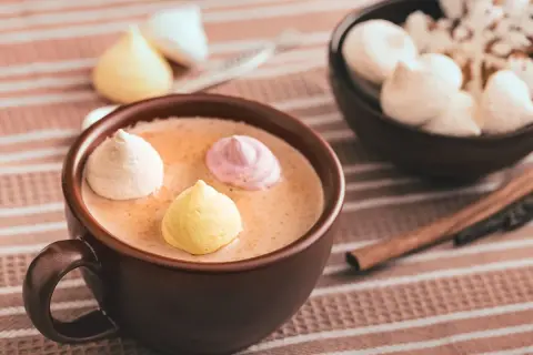 Chocolat chaud au lait d'amande, garni de meringues colorées. Un délice réconfortant.