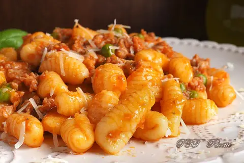 Gnocchetti sardi con ragù e piselli, un piatto gustoso ispirato alle ricette della Sardegna.