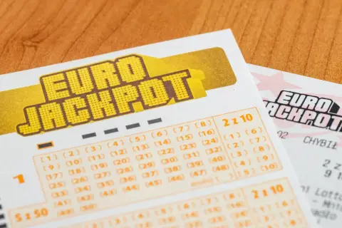 Kupony gry liczbowej Eurojackpot na drewnianym tle.