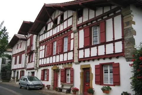 Maison basque typique, peut-être l'origine du nom Ithurburu. Volets rouges, colombages blancs, une voiture garée.