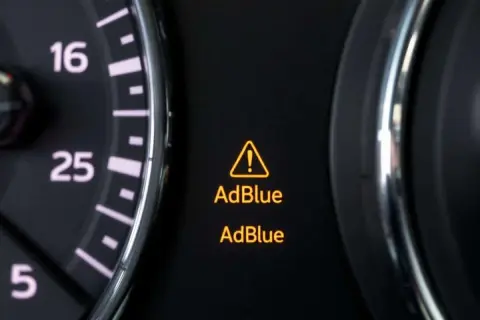 Tableau de bord d'une voiture affichant un voyant AdBlue allumé, signalant un problème avec le système AdBlue.