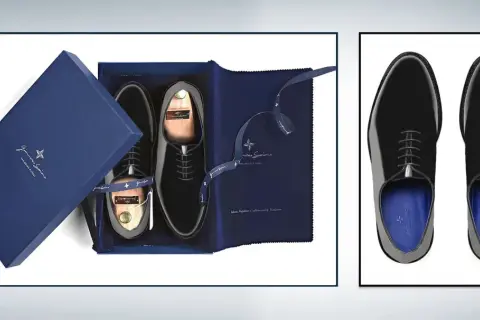 Eleganti scarpe smoking nere lucide, presentate in una scatola blu con accessori e calzascarpe in legno.