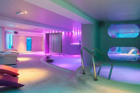 Relájate en los modernos spas en Benidorm, con piscinas termales, luces de neón y cómodas tumbonas.