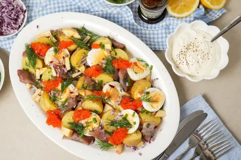 En härlig matjessill sallad med potatis, ägg, rödlök, äpple och rom. Perfekt för ett svenskt midsommarfirande eller sommarbuffé.