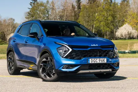Blå Kia Sportage, en begagnad bil som testas i soligt vårväder.