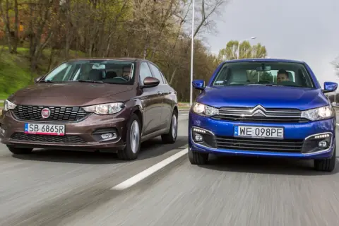 Brązowy fiat tipo sedan i niebieski Citroën jadą obok siebie po drodze.