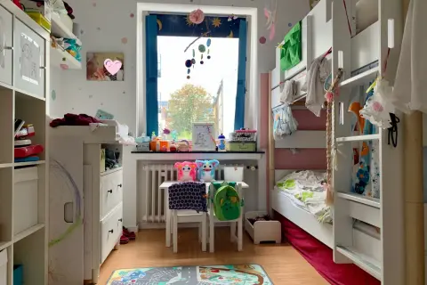 Ein gemütliches Kinderzimmer für einen Jungen von 7 Jahren, mit Hochbett, Spielzeug und einem bunten Teppich.