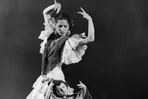 La familia Amaya flamenco, madre e hija bailan con pasión. La madre, con volantes y mantón, dirige la escena.