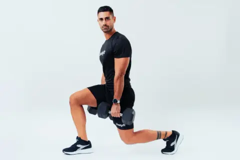 Uomo con manubri esegue affondi, un esercizio che rientra nel concetto di amrap significato: "as many reps as possible".
