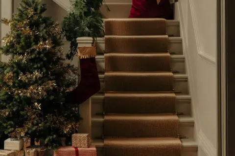 Festlich geschmückter Tannenbaum mit goldenen Zweigen und Geschenken. Die Frage "wann tannenbaum aufstellen" wird hier mit vorweihnachtlicher Deko beantwortet.
