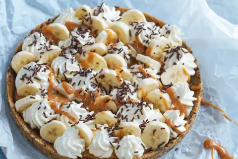 En läcker banoffee paj i glas, toppad med bananskivor, vispgrädde, kolasås och chokladströssel. Perfekt för en fika!