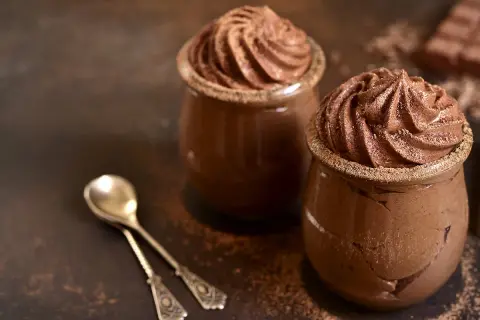 Deux verrines de mousse au chocolat, prêtes à être dégustées. Une invitation à réaliser cette recette facile et gourmande.