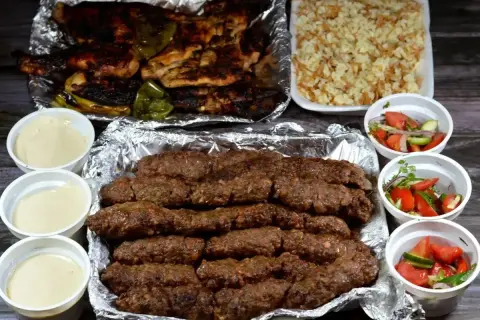 Pyszny kofta kebab z grillowanym kurczakiem, ryżem i sałatkami. Idealny posiłek dla całej rodziny.