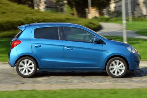 Niebieski Mitsubishi Space Star w ruchu. Wiele osób szuka Mitsubishi Space Star opinie, ten samochód miejski jest idealny do miasta.
