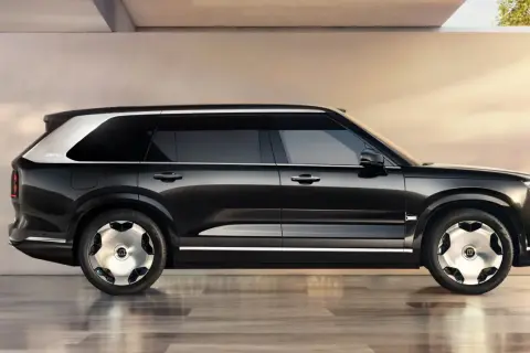 Svart Zeekr 9X SUV med silverdetaljer och unika fälgar, parkerad på ett glänsande golv.