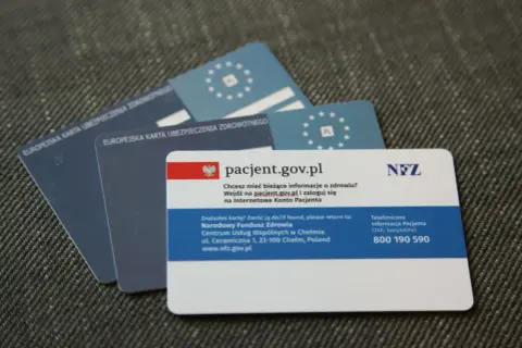 EKUZ, czyli Europejska Karta Ubezpieczenia Zdrowotnego, to dokument potwierdzający prawo do świadczeń medycznych w UE. Na zdjęciu widać kilka takich kart.