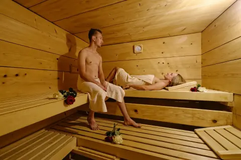 Ein Paar entspannt sich in einer Sauna. Vielleicht ist dies ein Teil eines **Bauernhofs in den Bergen**, wo man nach einem aktiven Tag in der Natur zur Ruhe kommen kann.