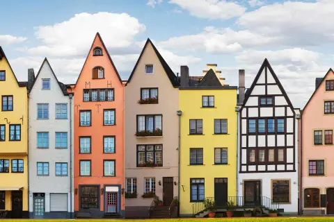 Bunte hausfassade farbe beispiele: Gelb, Weiß, Orange, Beige, Gelb, Weiß und Rosa Häuser reihen sich aneinander.