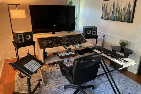 Ein Musikstudio mit einem großen Bildschirm, Mischpult, Tastatur und einem Plattenspieler für das perfekte **vinyl setup**.
