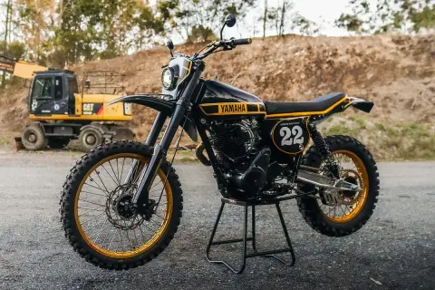 Yamaha XT 500 Dakar, negra y dorada, lista para la aventura. Excavadora CAT al fondo.