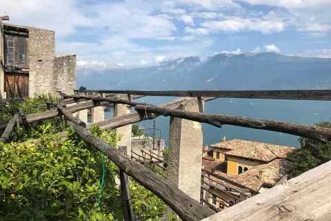 La **limonaia la malora** domina il lago, con le sue strutture in legno e le montagne sullo sfondo.