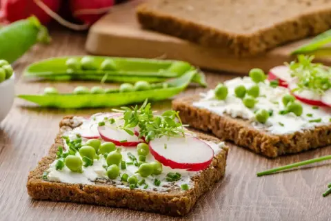 Frisches Vollkornbrot mit Frischkäse, Erbsen, Radieschen und Kresse – ein gesunder Aufschnitt für jeden Tag.