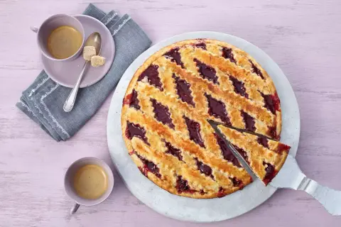 Ein köstliches Linzer Torte Rezept: goldbrauner Teig mit fruchtiger Marmelade, serviert mit Kaffee.