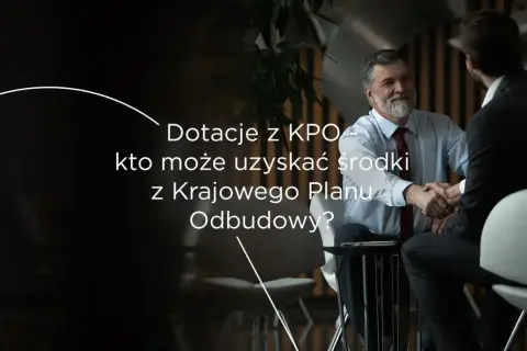 Dotacje z KPO – kto może uzyskać środki z Krajowego Planu Odbudowy? Dwóch mężczyzn w garniturach ściska sobie dłonie.
