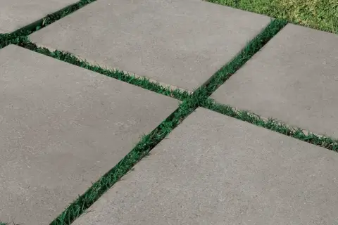 Percorso moderno con piastrelle da esterno 2 cm grigie, alternate a strisce di erba verde.