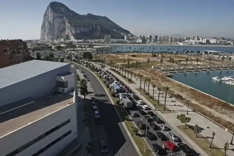 Larga cola de coches para visitar Gibraltar. El Peñón domina el paisaje.