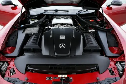 Le capot ouvert révèle le puissant moteur AMG d'une Mercedes rouge. Ce moteur, bien que différent d'un moteur Renault, est une merveille d'ingénierie.