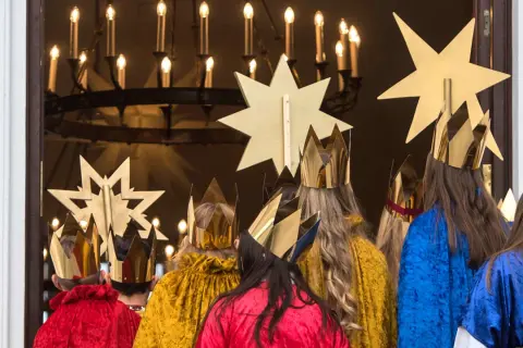 Sternsinger in goldenen Kronen und bunten Gewändern, bereit für den 7. Januar, das Weihnachtsfest.