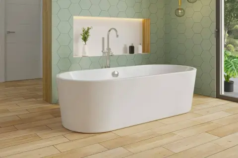 Une élégante baignoire îlot blanche trône sur un parquet en bois clair, sous un mur aux carreaux hexagonaux vert menthe.