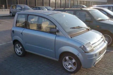 Jasnoniebieski, miejski auto od 16 lat, zaparkowane na kostce brukowej.