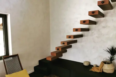 Escaliers flottants en bois sur un mur texturé, une belle deco peinture murale moderne.