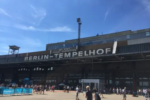 Människor samlas framför den ikoniska byggnaden för Berlins gamla flygplats, Tempelhof.