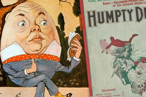 Humpty Dumpty siedzi, czyta książkę. Obok plakat "Humpty Dumpty" z diabłem i klaunem. Królu mój tekst.