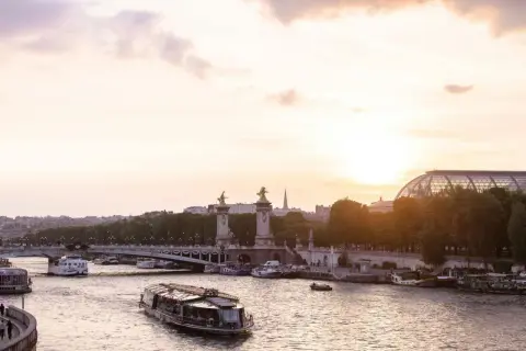 Boote auf der Seine bei Sonnenuntergang, eine malerische Szene, die die beste Reisezeit Paris widerspiegelt.