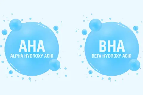 Dwa bąbelki z napisem AHA (Alpha Hydroxy Acid) i BHA (Beta Hydroxy Acid). Kwasy AHA jakie to? To składniki kosmetyków.