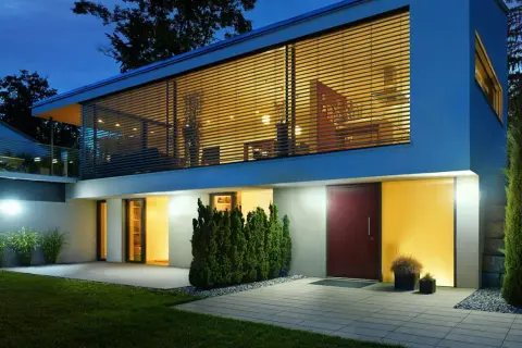 Nowoczesny dom z dużymi oknami, piękne oświetlenie budynku podkreśla jego architekturę.