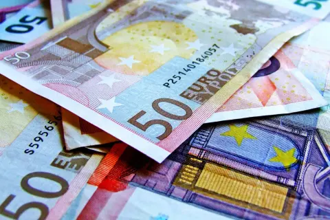 Stos pięćdziesięcioeuroowych banknotów. Widać fragmenty z cyfrą 50 i napisem "EURO".