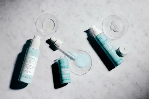 Varias botellas y un gotero de productos Sensilis sobre fondo de mármol. Opiniones sobre serum Sensilis: Pure Age Perfect [Retinal] y Azelaic [Peel].