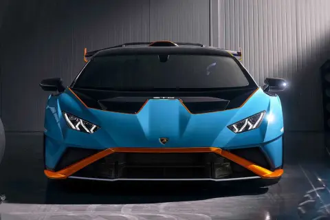 Niebieski Lamborghini Huracan STO z pomarańczowymi akcentami, gotowy do wyjazdu na tor.