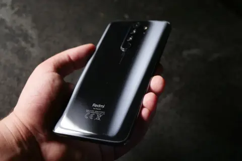 Dłoń trzyma czarny Redmi Note 8 Pro. Wymiary telefonu pozwalają na wygodne użytkowanie.