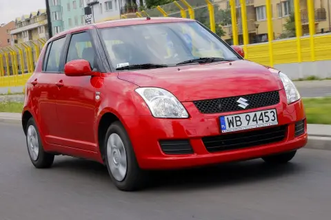 Czerwony Suzuki Swift 2008 na drodze, z widocznymi tablicami rejestracyjnymi WB 94453.