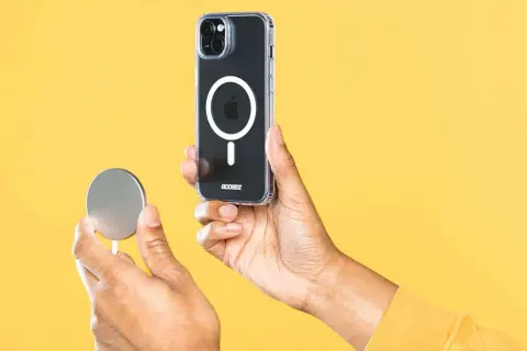 Découvrez magsafe c'est quoi : un chargeur rond magnétique se fixe à l'arrière d'un iPhone dans une coque transparente.